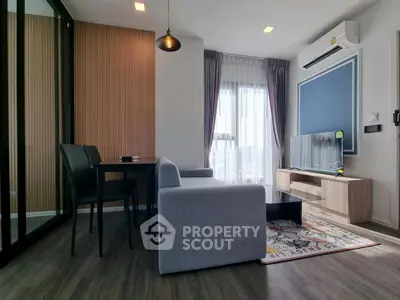 Modern living room with stylish decor, featuring a cozy sofa, dining area, and large window for natural light.