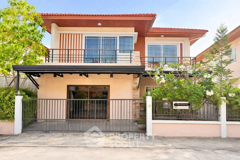 Charming two-story house with modern facade and lush greenery, perfect for family living.