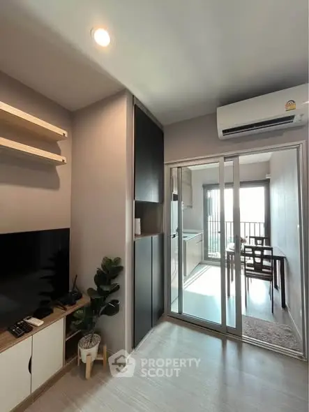 Modern living room with sliding glass doors leading to a bright balcony.