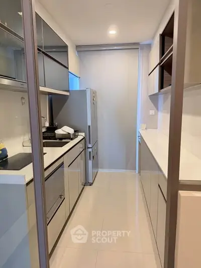 Modern kitchen with sleek cabinetry and stainless steel appliances in a compact layout.