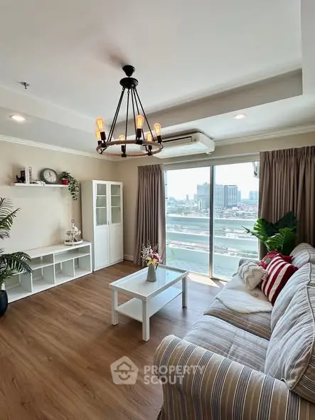 Stylish living room with modern chandelier and city view, featuring cozy striped sofa and elegant decor.