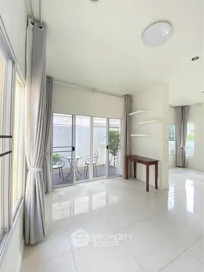 Spacious bright living room with large windows and balcony access, perfect for natural light lovers.