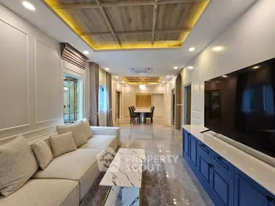 Luxurious modern living room with elegant decor and spacious layout, featuring a stylish ceiling design and large TV.