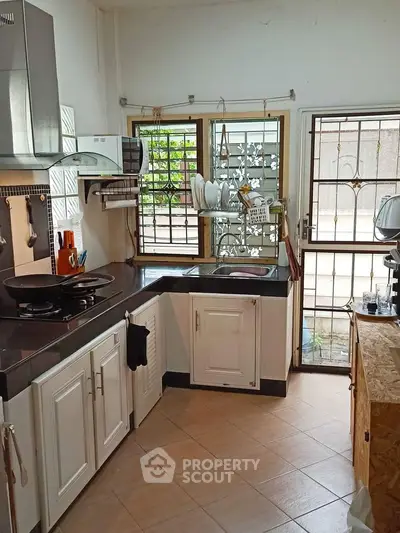 Charming kitchen with modern appliances and ample natural light, perfect for culinary enthusiasts.