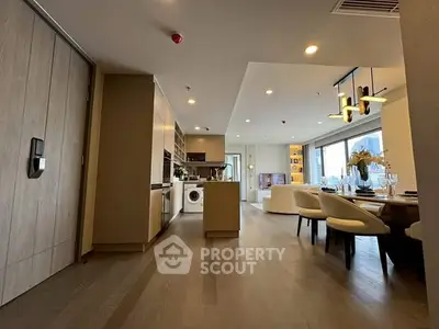 Modern open-plan kitchen and living area with stylish dining setup and natural light.