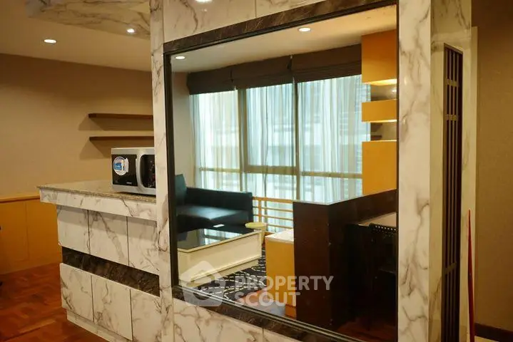 Stylish modern living room with marble accents and large windows for natural light.