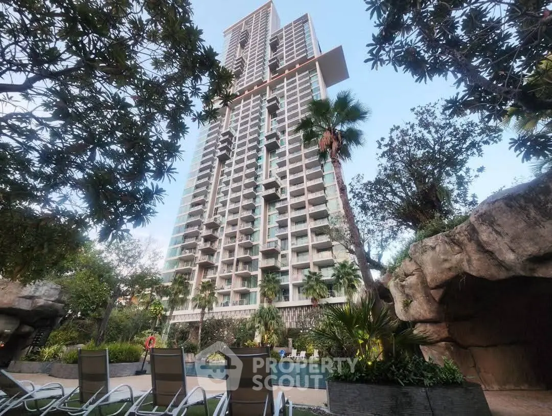 Stunning high-rise building with lush garden and pool area, perfect for luxury living.