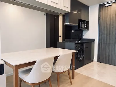 Modern kitchen with sleek appliances and elegant dining area in a stylish apartment.