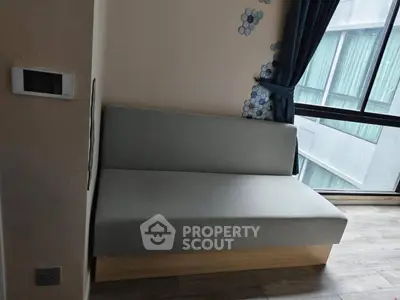 Modern minimalist living room with sleek sofa and large window view.