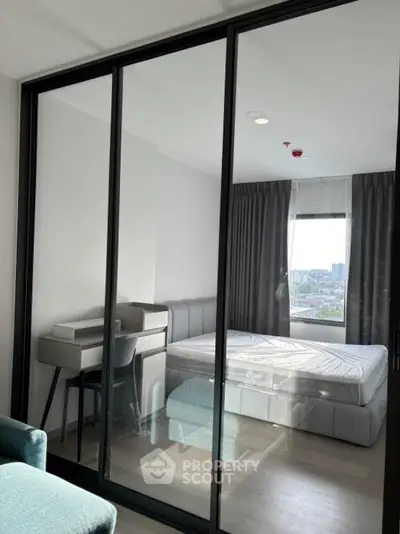 Modern bedroom with glass partition and city view in high-rise apartment