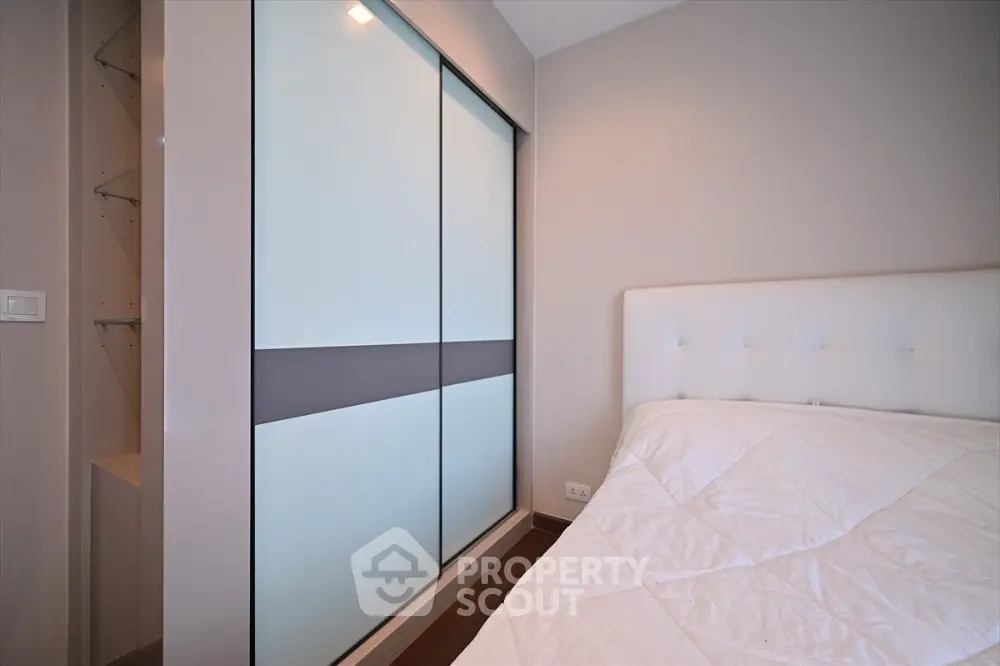 Modern bedroom with sleek sliding closet doors and cozy bed