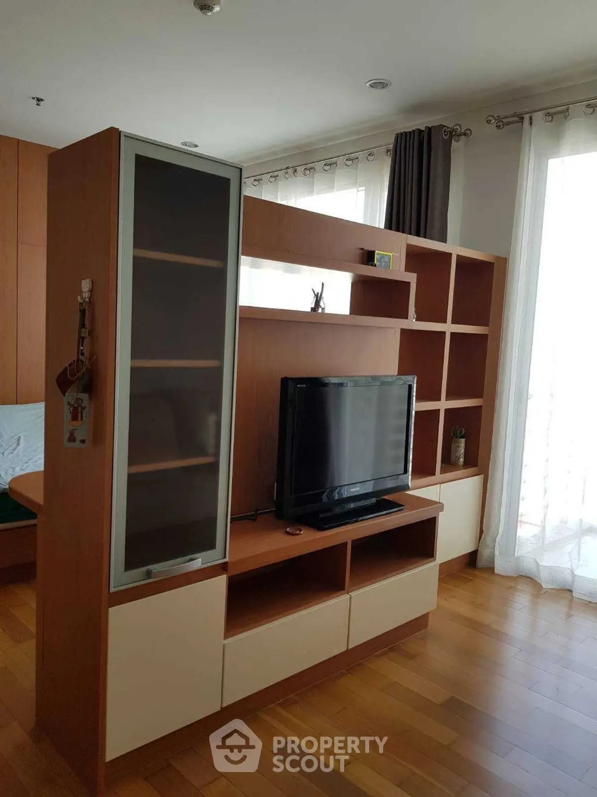 Modern living room with stylish wooden TV cabinet and natural light