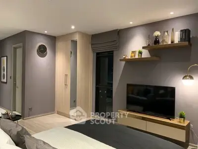Modern bedroom with sleek design, featuring a wall-mounted TV, stylish shelves, and elegant lighting.