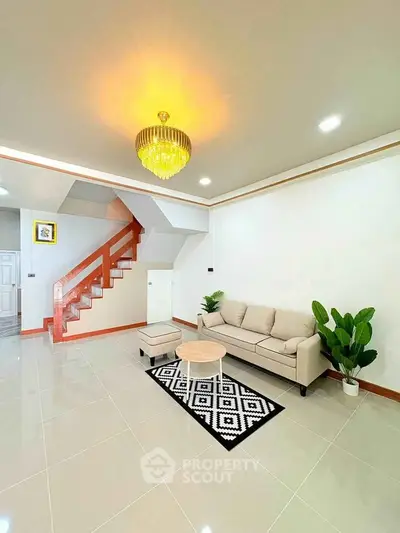 Modern living room with elegant chandelier and stylish staircase