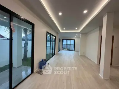 Spacious modern living room with large windows and sleek lighting