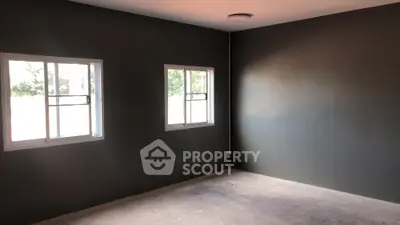 Spacious empty room with large windows and natural light