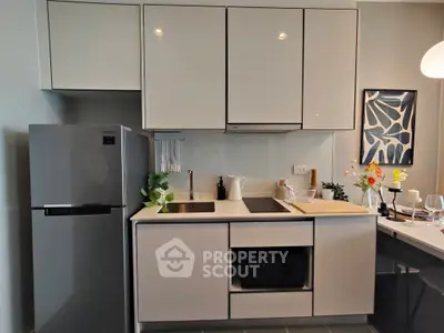 Modern kitchen with sleek cabinetry, integrated appliances, and stylish decor in a contemporary apartment.