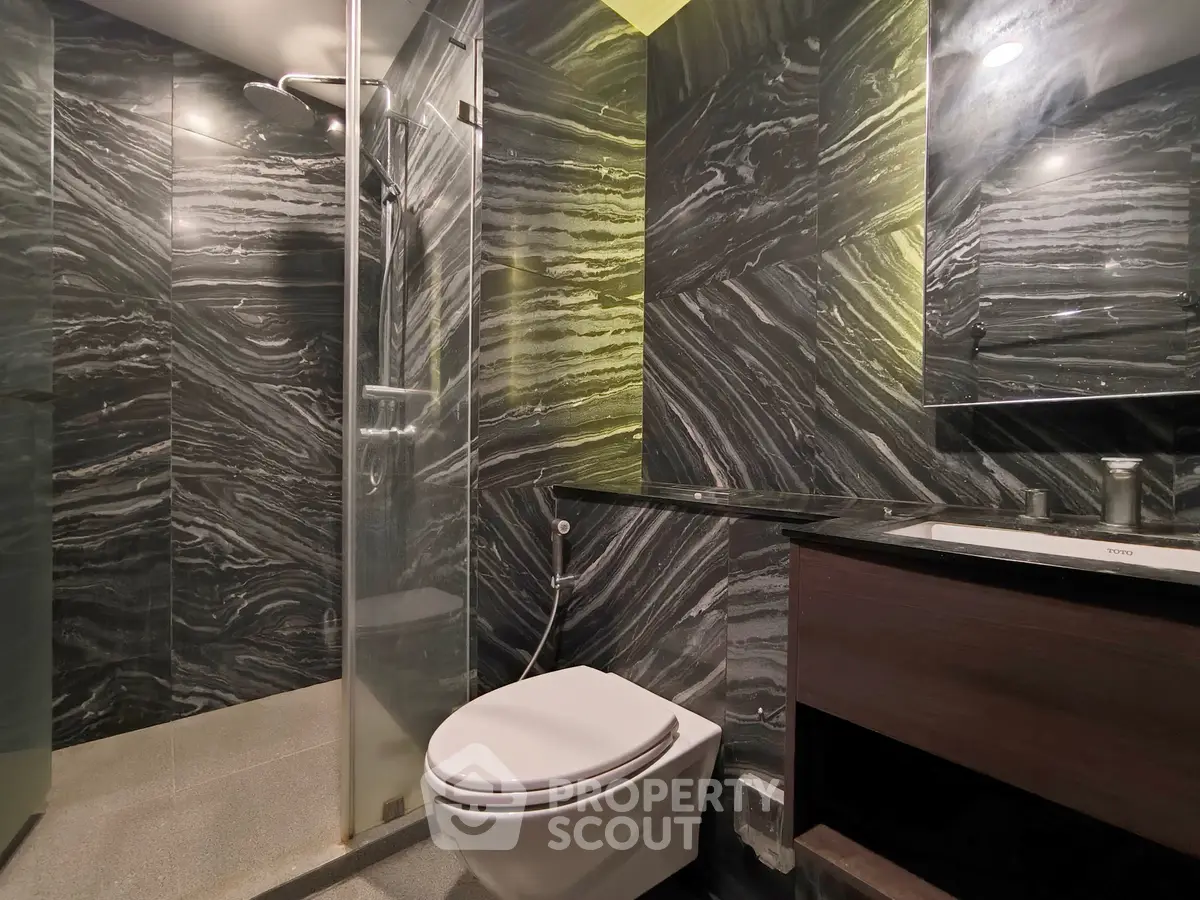 Luxurious modern bathroom with sleek marble walls and glass shower enclosure