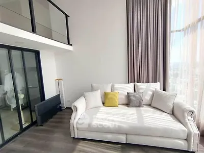 Spacious modern living room with high ceilings and large windows offering abundant natural light.