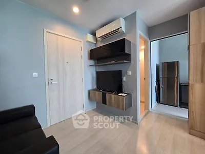 Modern living room with sleek TV setup and air conditioning in stylish apartment.