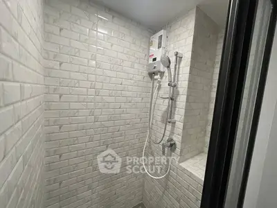 Modern bathroom shower with sleek white tile design and built-in water heater