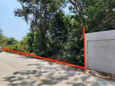 Prime land plot with lush greenery and road access, ideal for development.