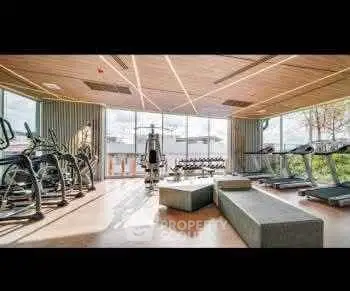 Modern gym with state-of-the-art equipment and scenic views in luxury residential building.