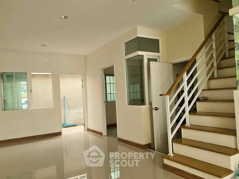 Spacious modern interior with sleek staircase and large windows, perfect for natural light lovers.