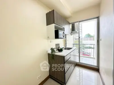 Modern compact kitchen with sleek cabinetry and balcony view