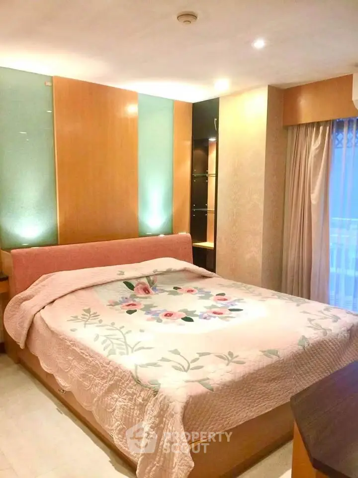 Cozy bedroom with elegant lighting and floral bedding in a modern apartment.
