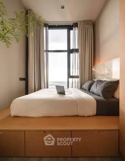 Modern bedroom with large window and cozy bed, featuring a sleek design and natural light.