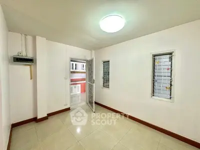 Bright empty room with tiled floor and barred windows in a modern apartment.