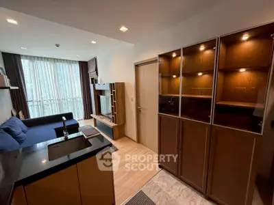 Modern living room with sleek furniture and built-in cabinets, featuring large windows for natural light.