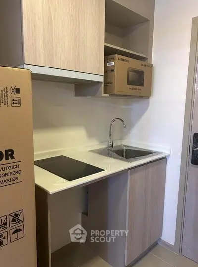 Modern compact kitchen with built-in appliances and sleek cabinetry