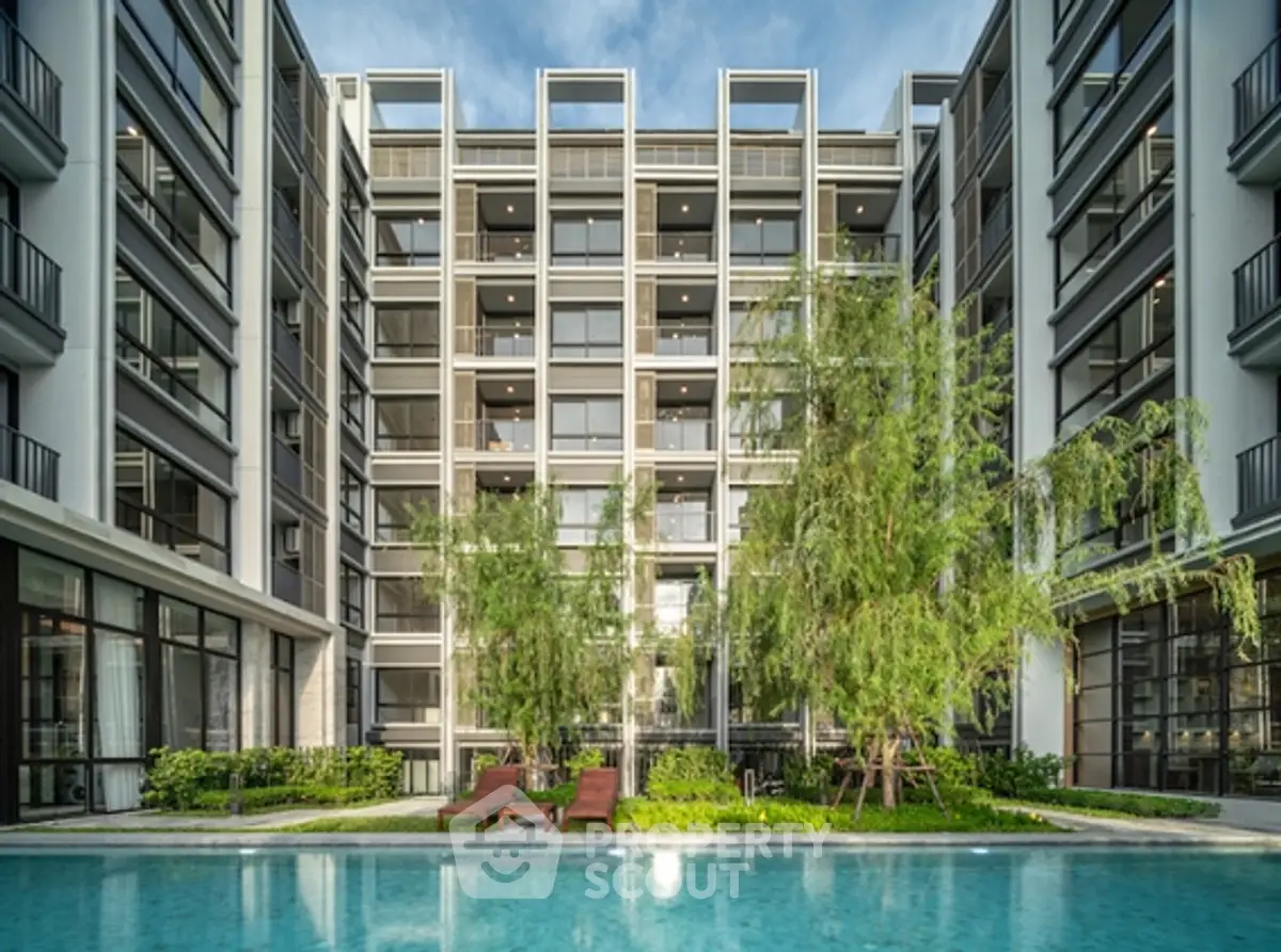 Luxurious modern apartment building with pool and lush greenery, perfect for urban living.