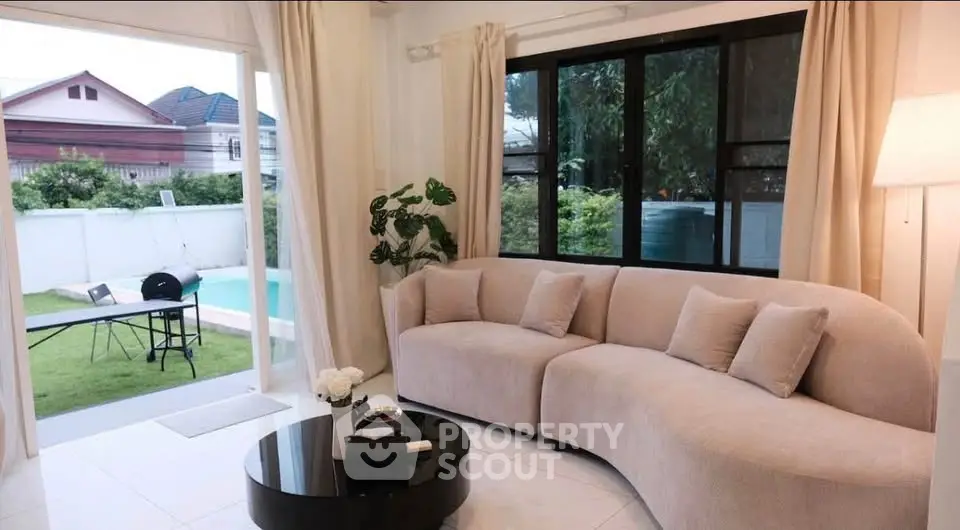 Stylish living room with curved sofa and garden view, perfect for relaxation.