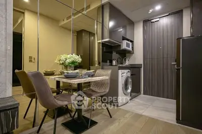Modern kitchen with dining area, washing machine, and sleek cabinetry in a compact apartment.