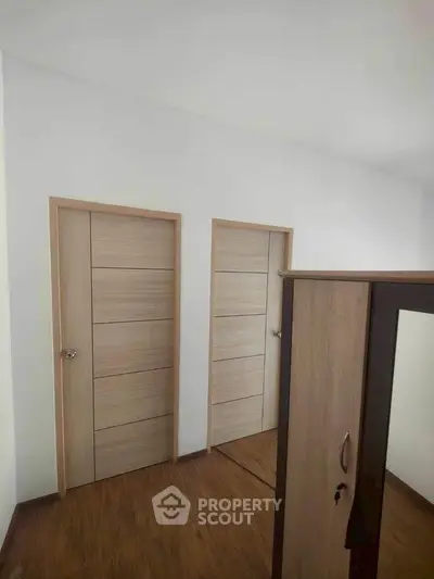 Modern interior with wooden doors and wardrobe in a minimalist design.