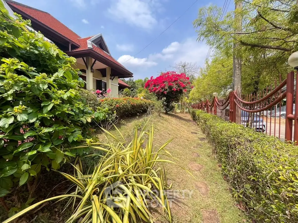 Charming garden path leading to a picturesque house with lush greenery and vibrant flowers.