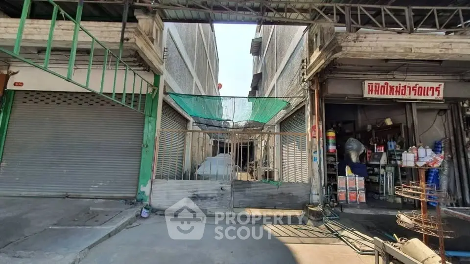 Commercial building exterior with closed shutters and gated entrance, ideal for business opportunities.