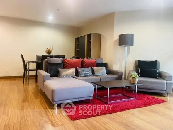 Spacious living room with modern furniture and vibrant red rug