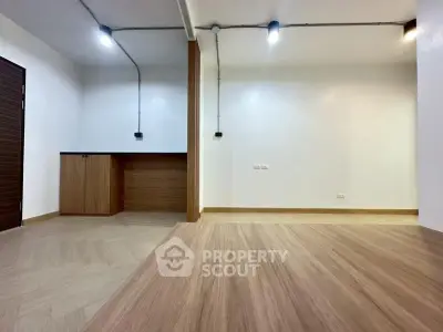 Modern minimalist interior with wood flooring and built-in storage, ideal for versatile living spaces.