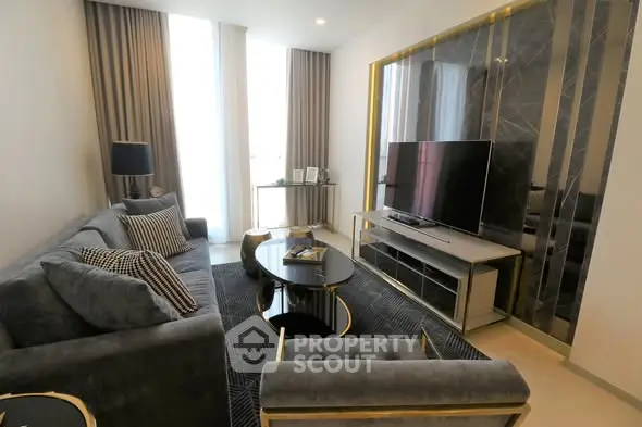 Luxurious modern living room with elegant decor and large flat-screen TV.