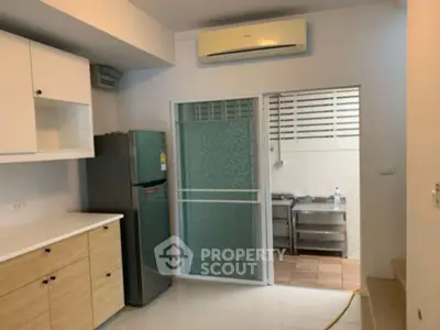 Modern kitchen with sleek cabinets and stainless steel fridge in a compact layout.