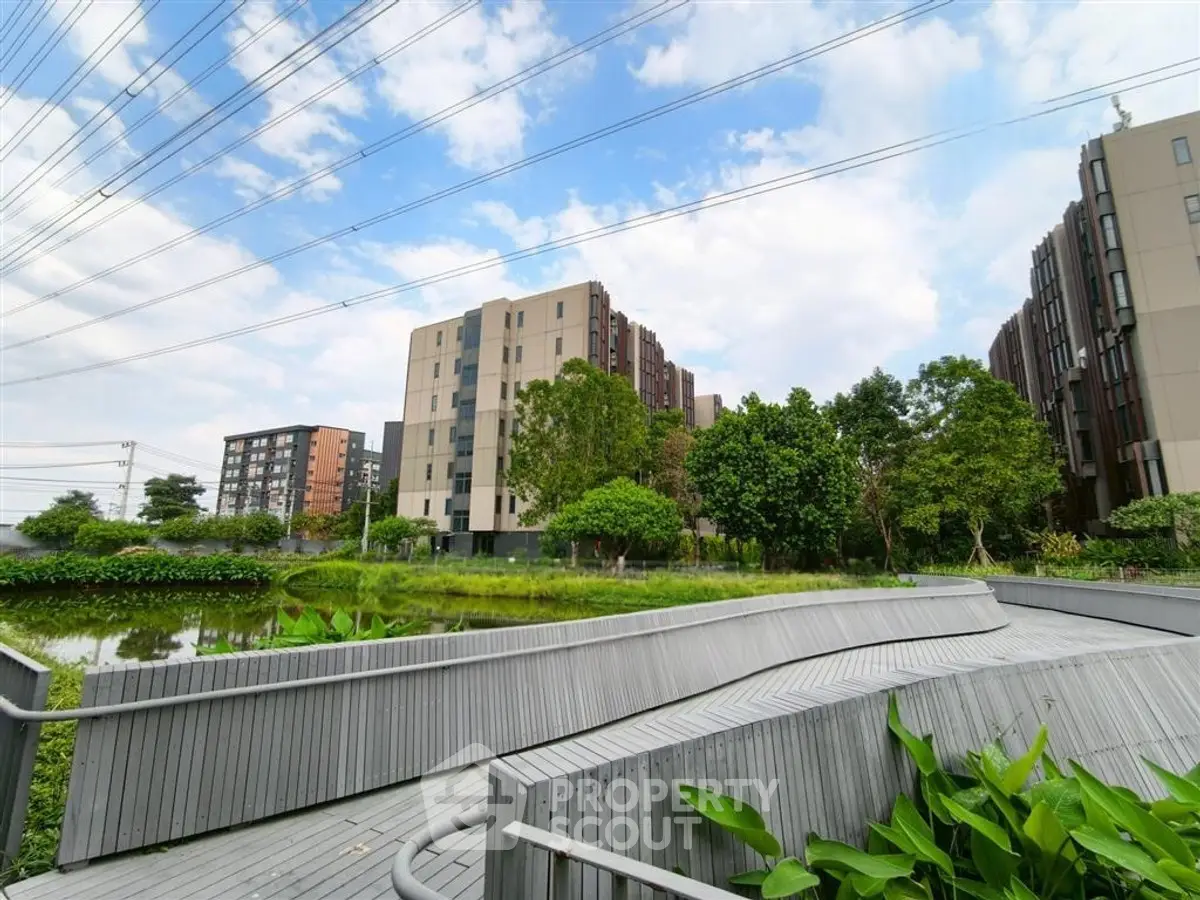 Modern apartment complex with lush greenery and serene pond view