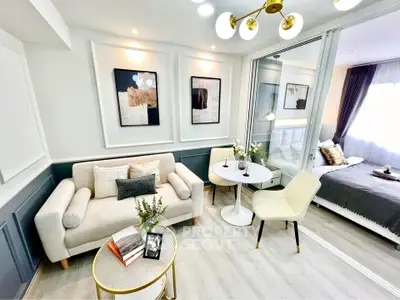 Modern open-plan living room with elegant decor and cozy bedroom area.