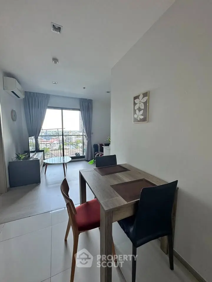 Modern living room with dining area and balcony view in a stylish apartment.