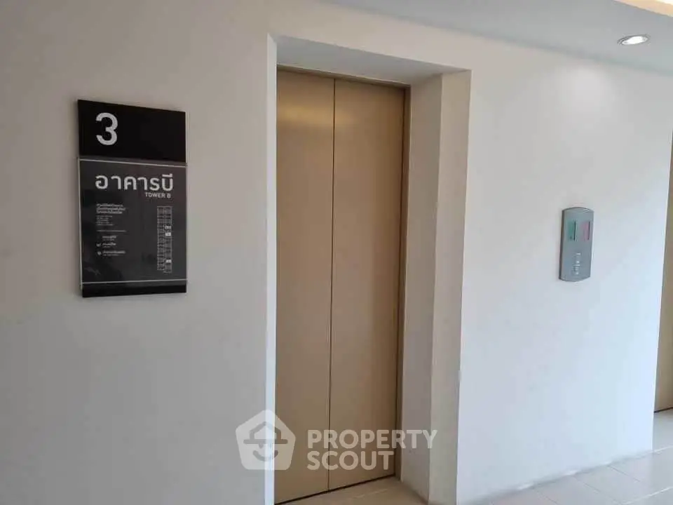 Modern elevator entrance in a sleek residential building with clear signage.