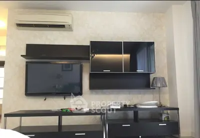 Modern living room with sleek black furniture and wall-mounted TV, featuring elegant wallpaper and air conditioning.