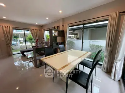 Spacious modern living room with dining area and large windows offering garden views.